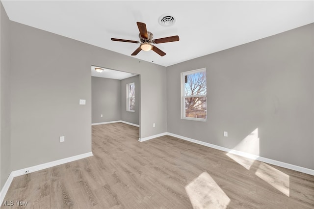 unfurnished room featuring visible vents, baseboards, a ceiling fan, and light wood finished floors