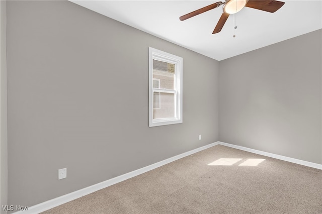 carpeted empty room with baseboards and a ceiling fan