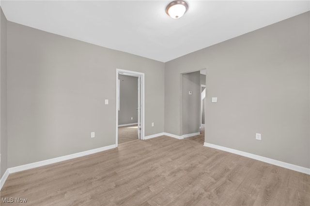 unfurnished room featuring light wood-style flooring and baseboards