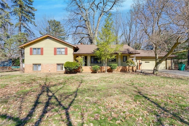 tri-level home featuring a front lawn, an attached garage, and driveway