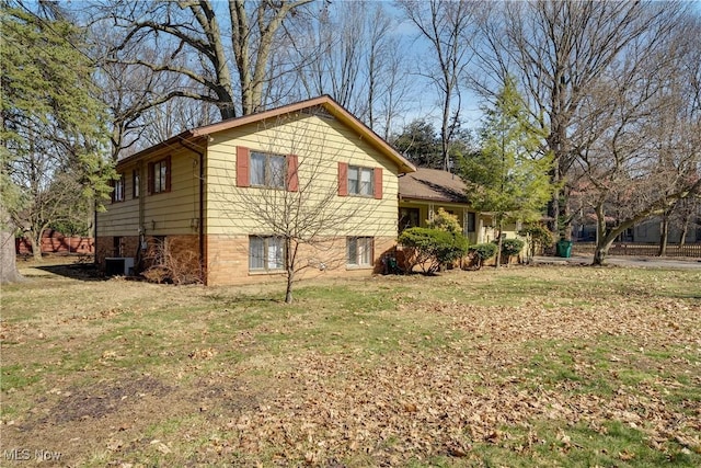 view of side of property with central air condition unit and a yard