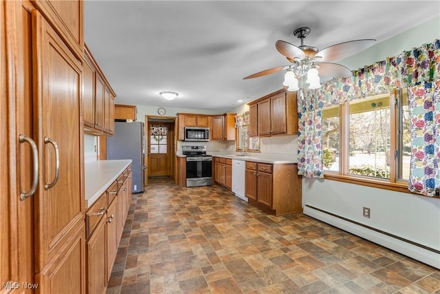 kitchen featuring stone finish flooring, a baseboard heating unit, light countertops, brown cabinets, and stainless steel appliances