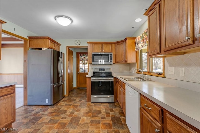 kitchen featuring a sink, brown cabinets, appliances with stainless steel finishes, and light countertops