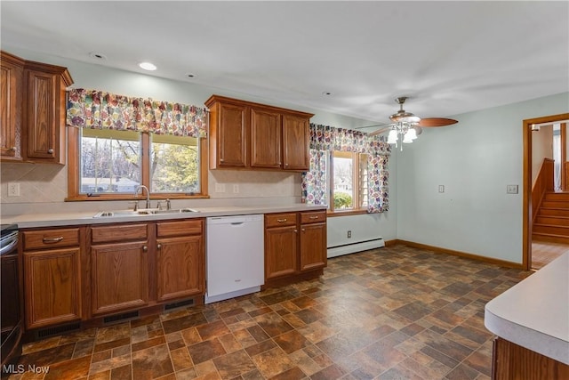 kitchen with a sink, a baseboard radiator, brown cabinets, and white dishwasher