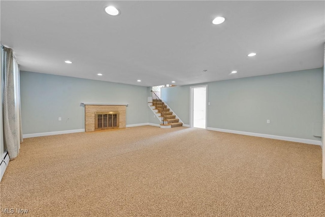 finished below grade area with baseboards, stairs, carpet floors, recessed lighting, and a fireplace