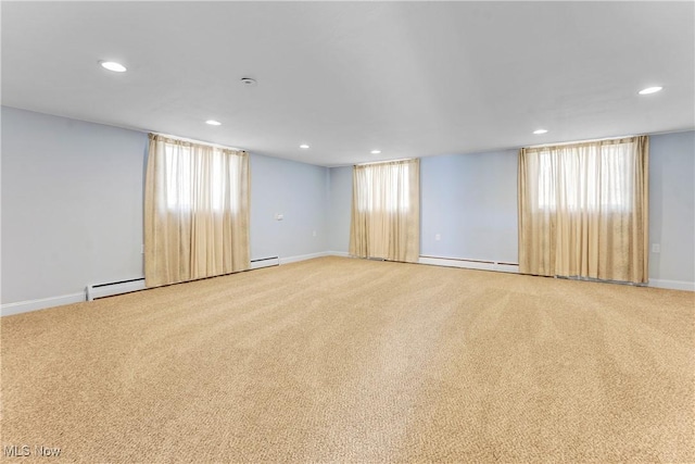 spare room with recessed lighting, carpet, plenty of natural light, and a baseboard radiator