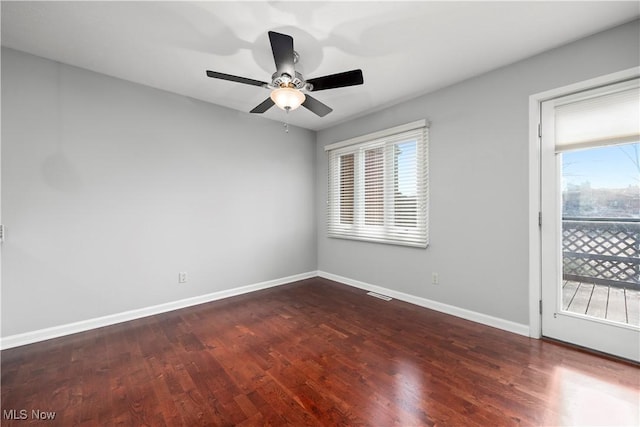 empty room featuring visible vents, dark wood-style floors, baseboards, and ceiling fan