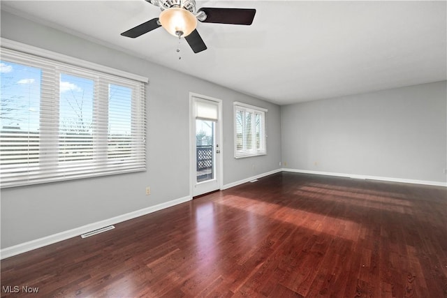 unfurnished room featuring ceiling fan, visible vents, baseboards, and wood finished floors