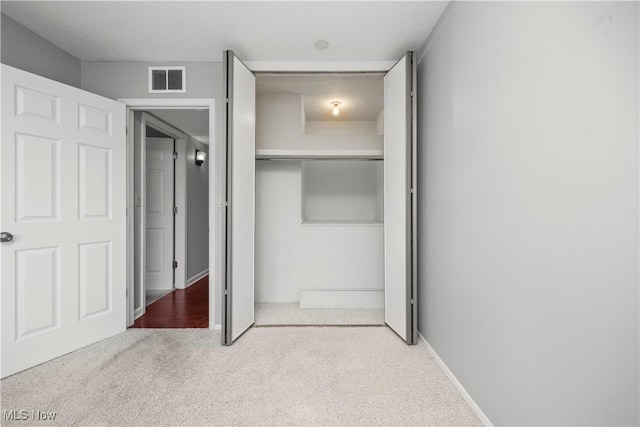 unfurnished bedroom featuring a closet, visible vents, and carpet floors