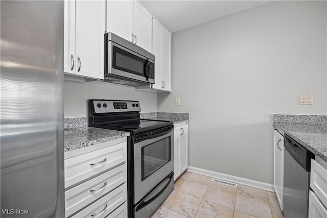 kitchen with visible vents, white cabinets, stainless steel appliances, and baseboards