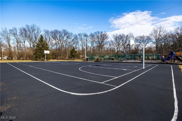 view of sport court with community basketball court, playground community, and fence