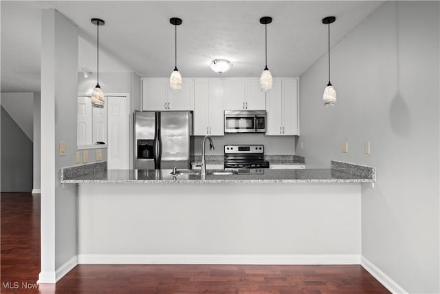 kitchen with a sink, a peninsula, light stone countertops, and stainless steel appliances