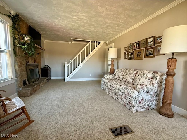 carpeted living area with stairs, crown molding, visible vents, and a wealth of natural light