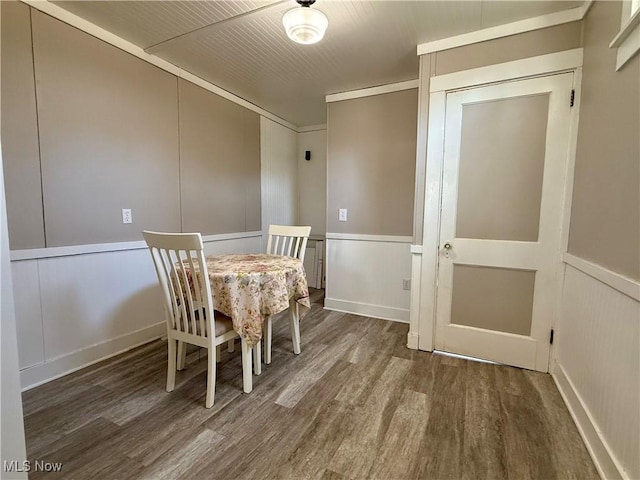 unfurnished dining area with wood finished floors and a decorative wall