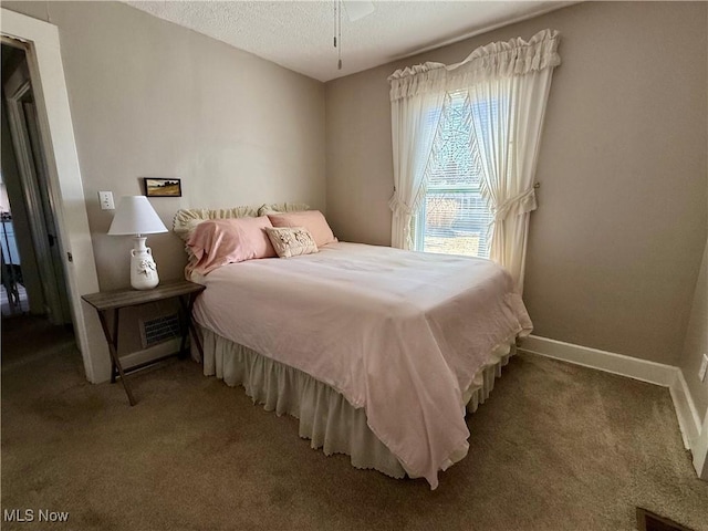 bedroom featuring visible vents, a textured ceiling, baseboards, and carpet