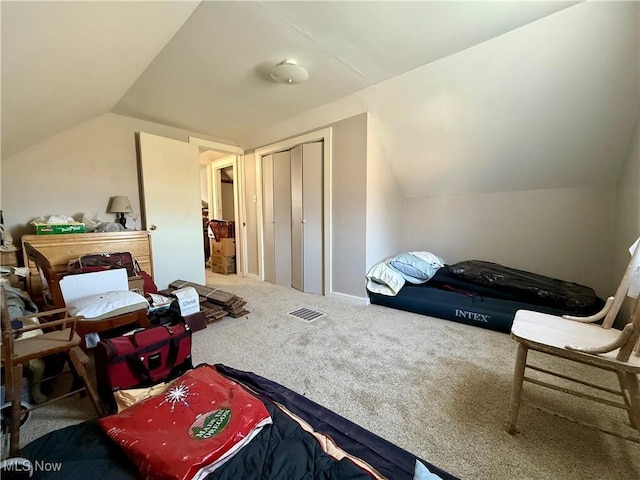 bedroom with a closet, vaulted ceiling, and carpet floors