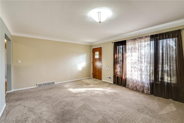 spare room featuring visible vents, baseboards, and carpet