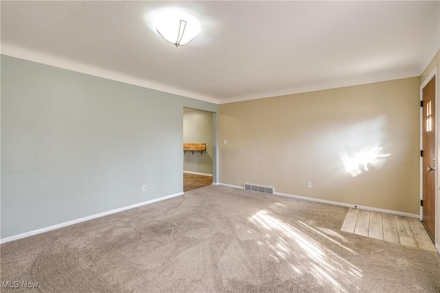 spare room with visible vents, baseboards, and carpet floors