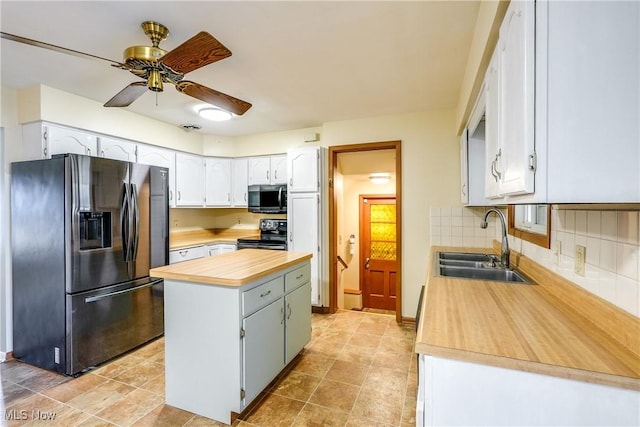 kitchen with a sink, black appliances, wood counters, backsplash, and a center island