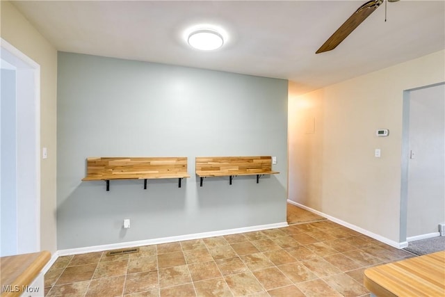 unfurnished dining area featuring visible vents, baseboards, and ceiling fan