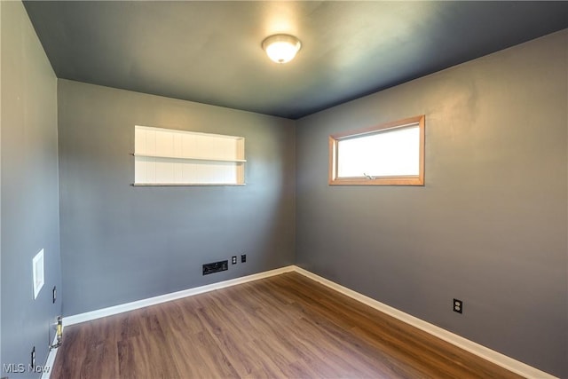 empty room featuring wood finished floors and baseboards