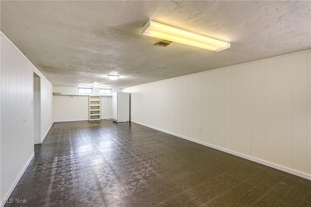 interior space with tile patterned floors, baseboards, visible vents, and a textured ceiling