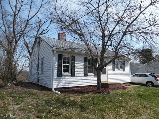 view of front of house featuring crawl space, a chimney, and a front lawn