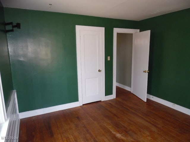 empty room featuring baseboards and wood finished floors