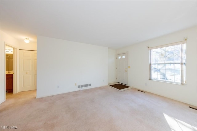 unfurnished living room with light carpet and visible vents