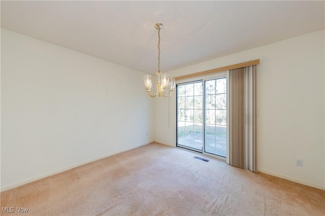 carpeted empty room with visible vents, baseboards, and a notable chandelier