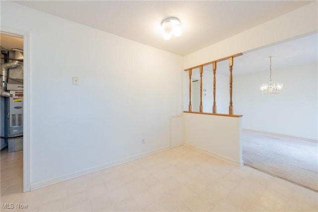 carpeted empty room with tile patterned floors, baseboards, and an inviting chandelier