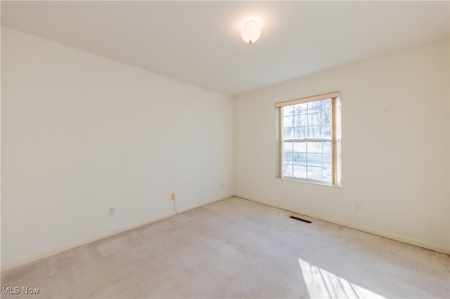 carpeted spare room featuring visible vents