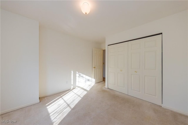 unfurnished bedroom with a closet and carpet flooring