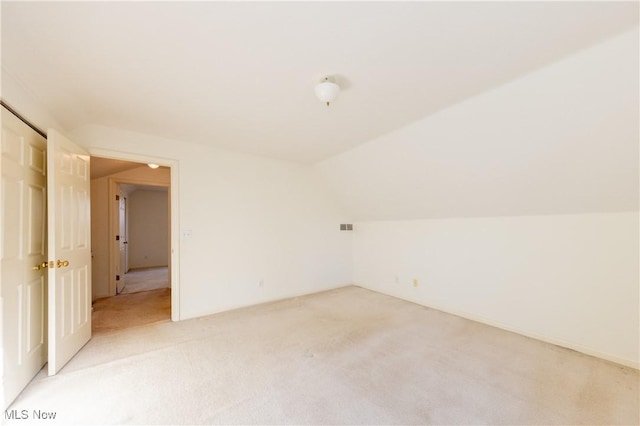 bonus room featuring vaulted ceiling and light carpet