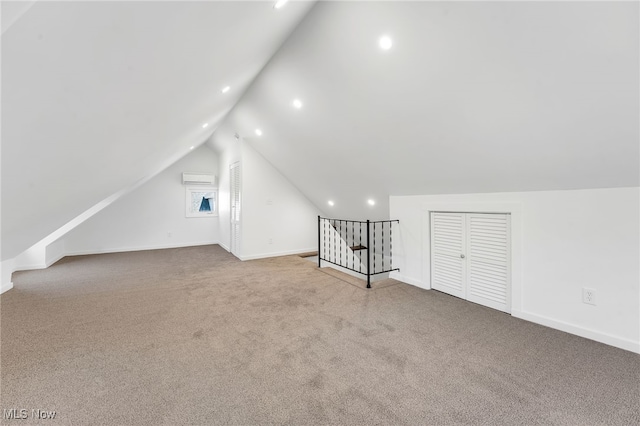 additional living space with baseboards, carpet, an AC wall unit, lofted ceiling, and recessed lighting