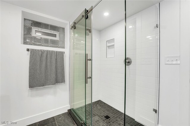 full bathroom featuring a stall shower and baseboards