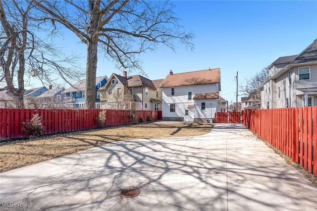 rear view of property with a residential view and a fenced backyard