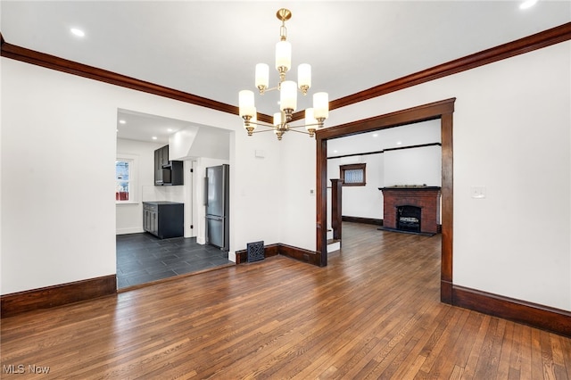 interior space with dark wood finished floors, ornamental molding, baseboards, and a chandelier