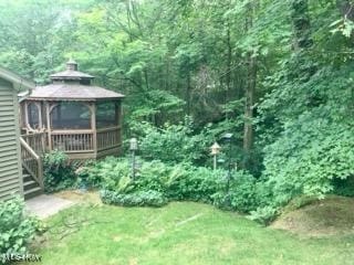 view of yard with a gazebo and a view of trees