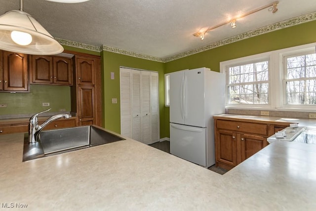 kitchen with a sink, light countertops, and freestanding refrigerator