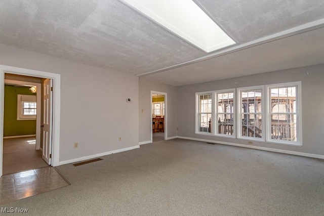 unfurnished living room with visible vents, baseboards, carpet, and a textured ceiling