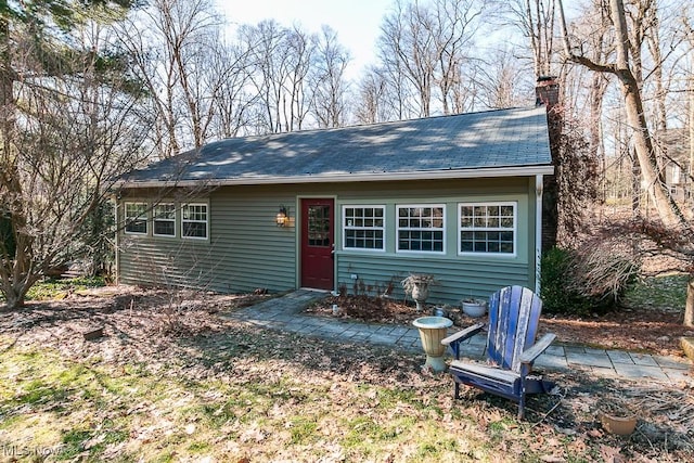 view of front of property with a chimney and roof with shingles