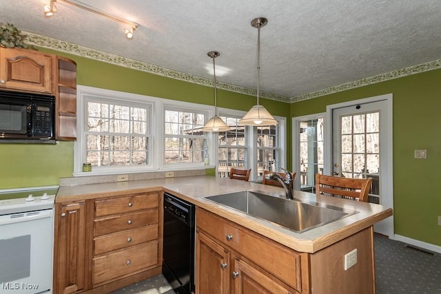 kitchen featuring a textured ceiling, black appliances, brown cabinets, and a sink