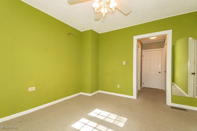 unfurnished room with baseboards, a ceiling fan, and carpet floors