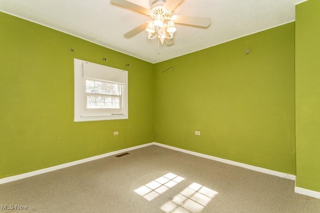 unfurnished room with carpet, baseboards, visible vents, and ceiling fan