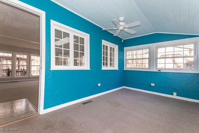 empty room with baseboards, visible vents, ceiling fan, vaulted ceiling, and carpet flooring