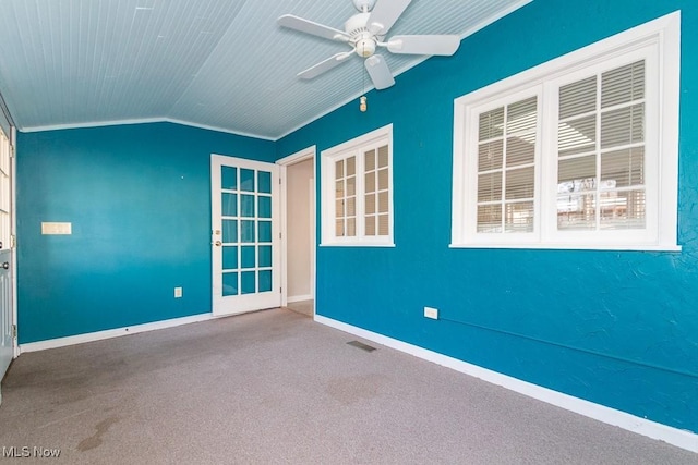 carpeted empty room with visible vents, a ceiling fan, baseboards, crown molding, and lofted ceiling