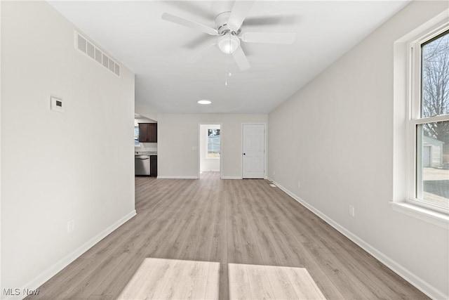 unfurnished living room featuring visible vents, baseboards, light wood-style floors, and ceiling fan