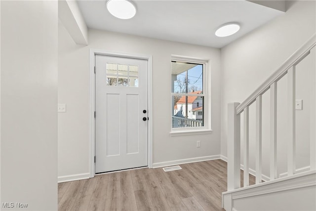 entrance foyer featuring visible vents, baseboards, and wood finished floors