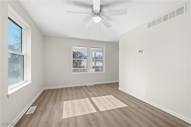 unfurnished room with visible vents, baseboards, and wood finished floors